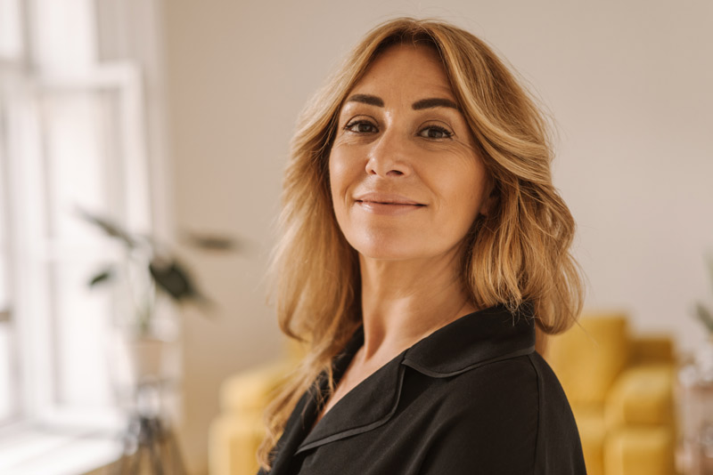 Mulher de meia idade após realizar procedimentos de Botox e preenchimento facial.