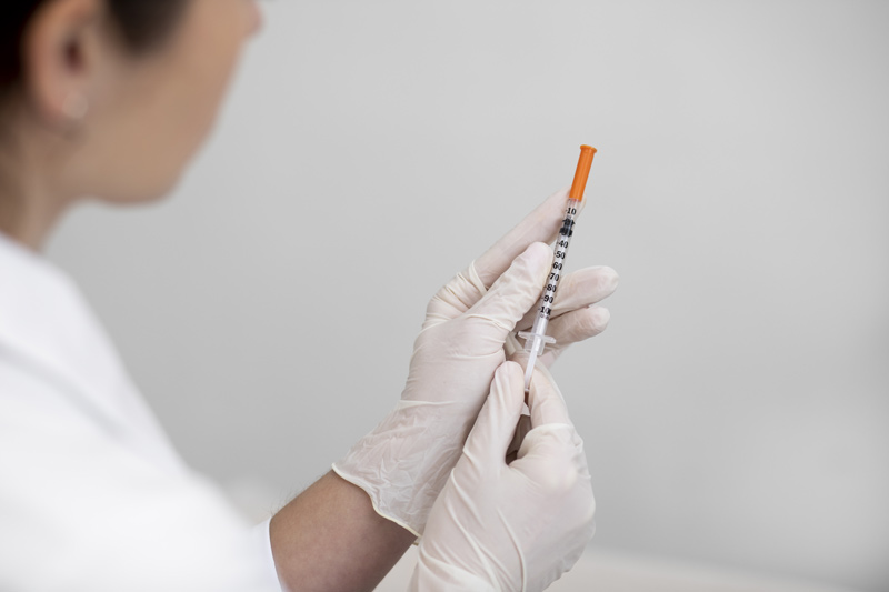 Profissional de estética segurando seringa com toxina botulínica (Botox) para aplicação em paciente.