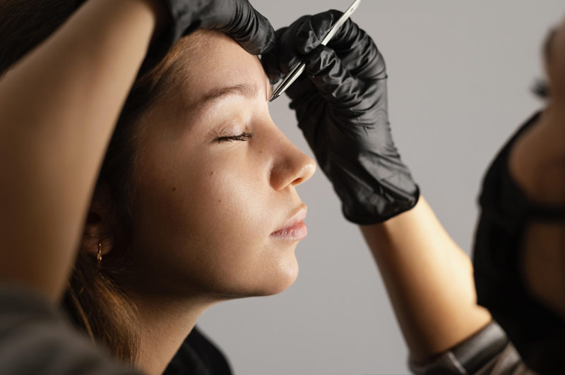 Profissional da estética fazendo marcação no rosto de paciente para aplicação de Botox ou toxina botulínica, que são a mesma coisa.