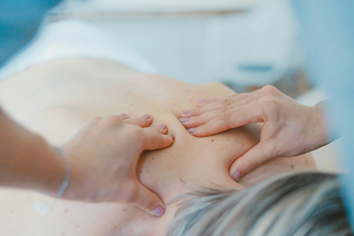 Mulher recebendo massagem nas costas.