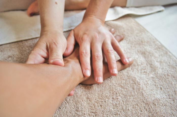 Profissional realizando massagem no braço.