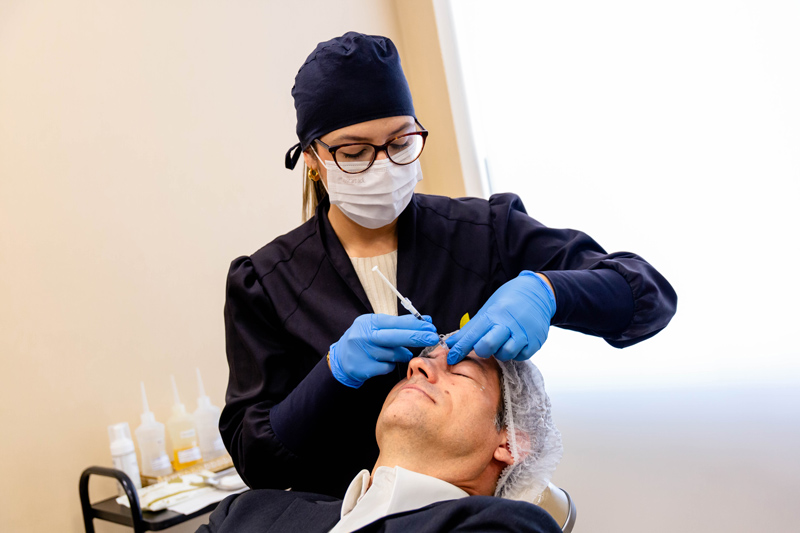 Profissional da Royal Face fazendo procedimento estético em homem, uma das tendências de beleza para 2026.