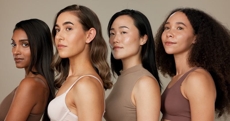 Quatro mulheres com diferentes fototipos de pele alinhadas lado a lado.