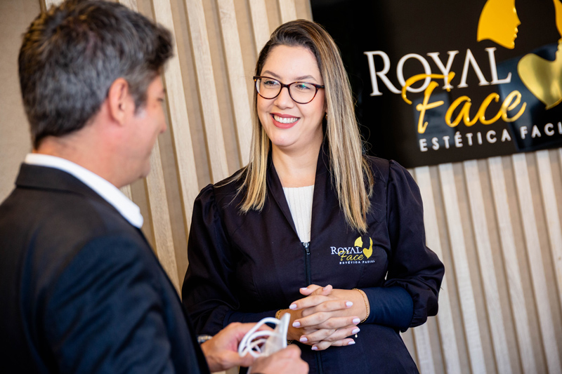 Homem conversando com profissional da Royal Face sobre motivos para investir em franquia de estética em 2026.