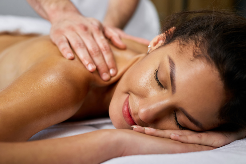Mulher recebendo massagem no ombro, ideal para ajudar com saúde emocional.