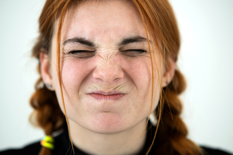 Mulher realizando expressões faciais, mostrando como o rosto reage.
