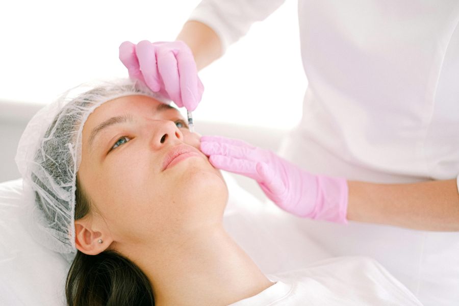 Biossegurança em clínica estética: profissional de saúde aplicando substância em paciente