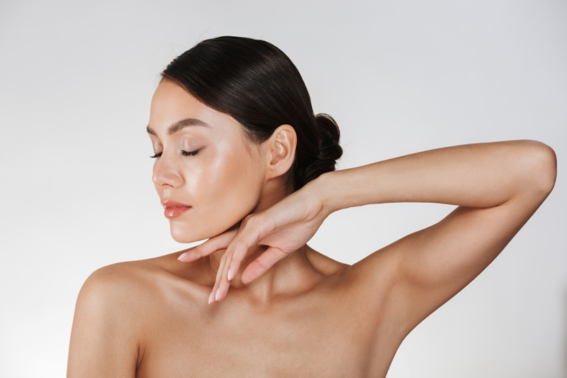 Mulher com pele saudável após realizar procedimentos estéticos faciais no inverno, pronta para o verão.