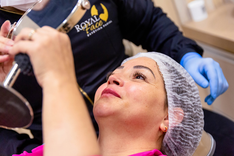 Paciente durante avaliação facial com profissional da Royal Face em clínica de estética.